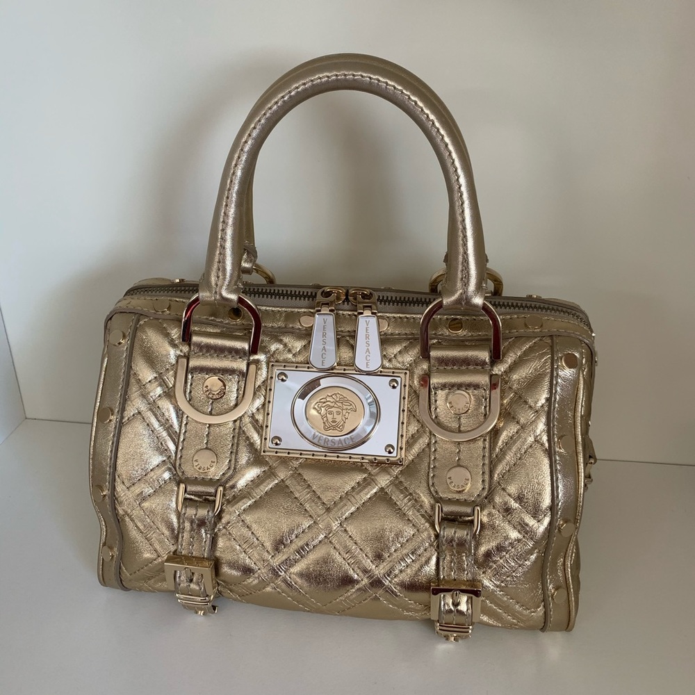 Hold Versace gold quilted handbag
